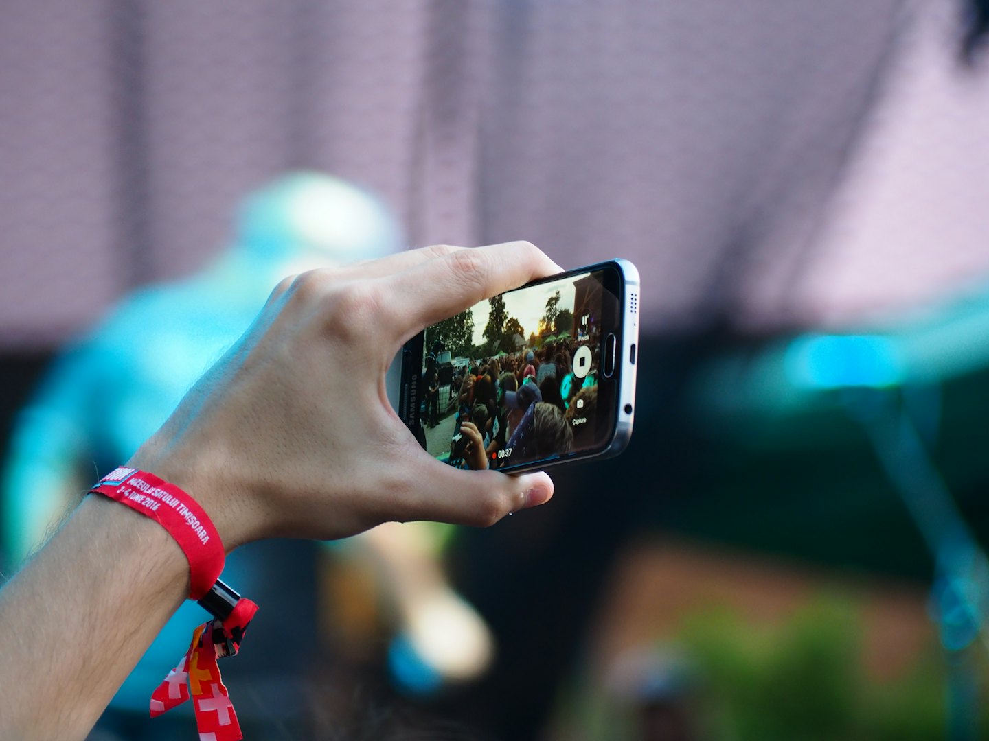 Mano che registra un concerto con uno smartphone.