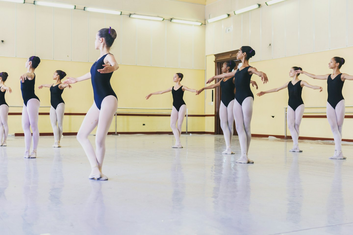 Giovani ballerini in uno studio che tengono una posizione di balletto composta.