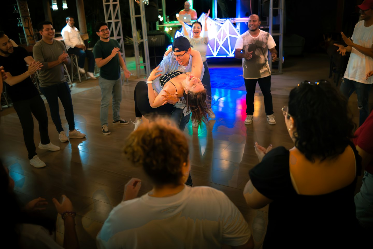 Coppia che balla in stile latino sotto luci colorate sul palco.