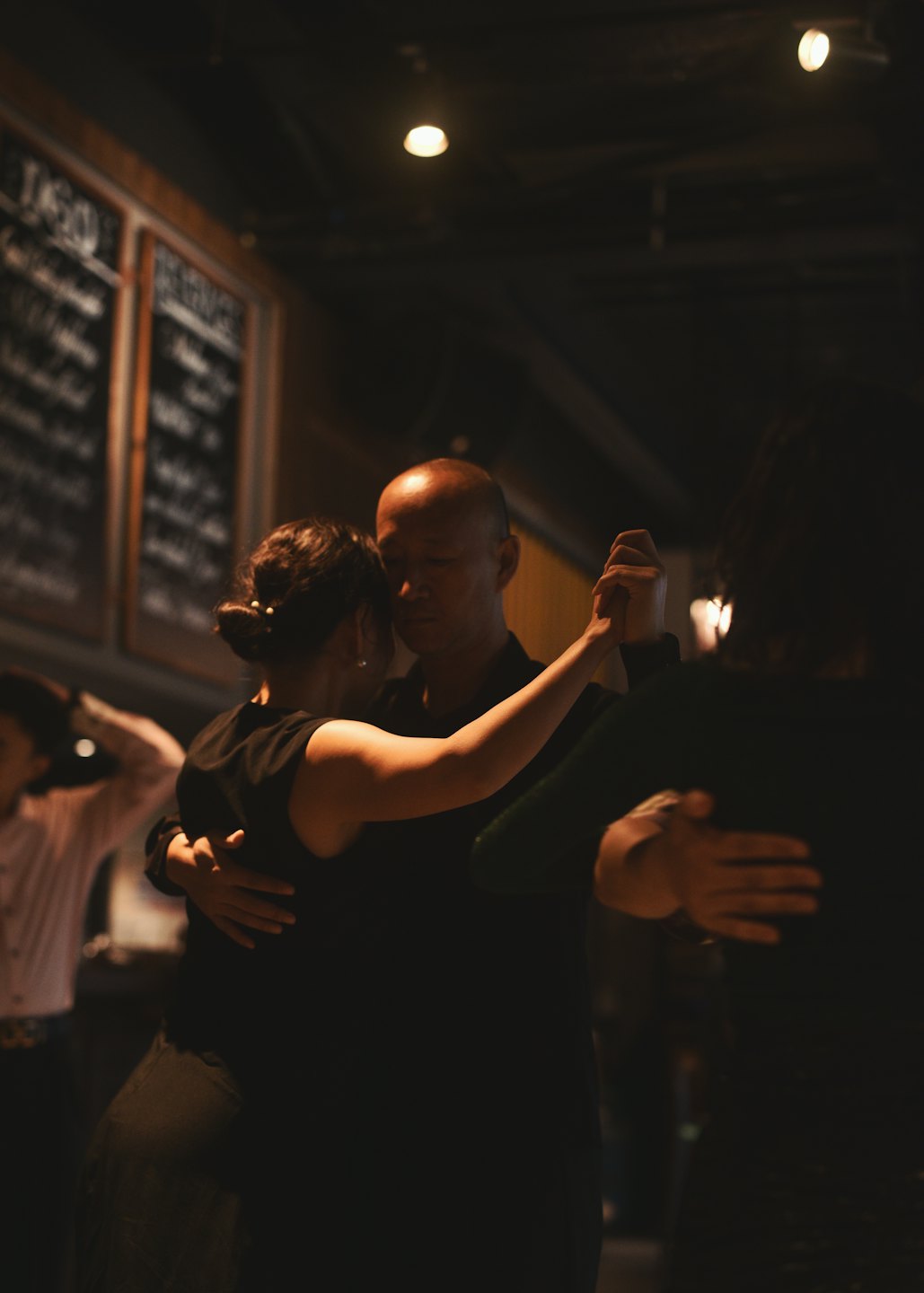 Una coppia balla il tango tenendosi per mano in uno studio.